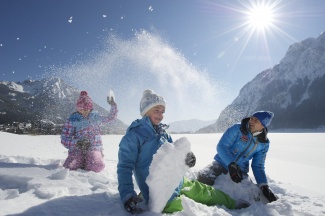 Schneeballschlacht mit Kindern im Urlaub in Tirol